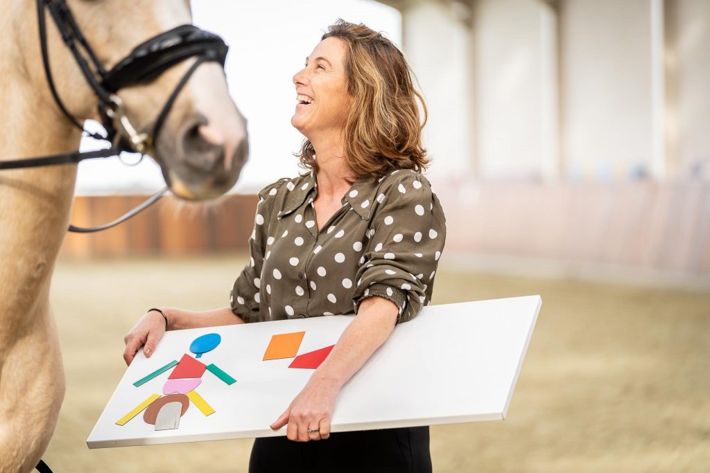 Afbeelding van Nynke van der Linden met een jonge ruiter waarbij ruiter niet volledig in beeld is