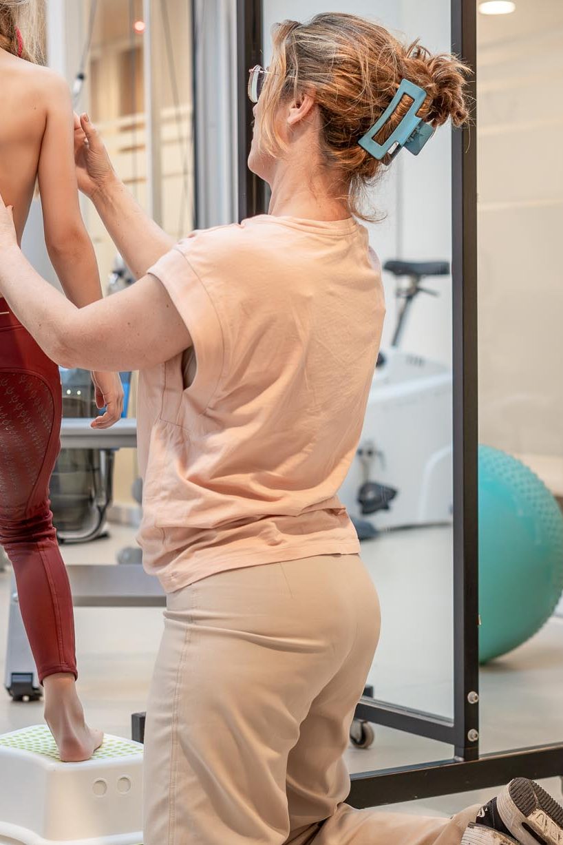 Afbeelding van Nynke van der Linden aan het werk met een jonge ruiter in de praktijk.